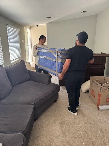 Mover specialists and a client in front of a home during a successful residential moving service operation.