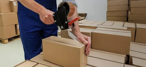Mover wrapping and preparing items into moving boxes, showcasing reliable Packing and Unpacking Services