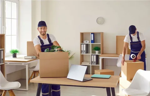 Worker sealing cardboard shipping containers in a commercial office environment for seamless office moving