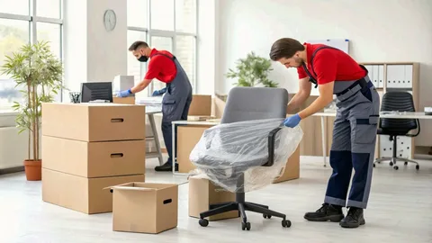 Man organizing and packing office equipment into relocation boxes for professional office moving services