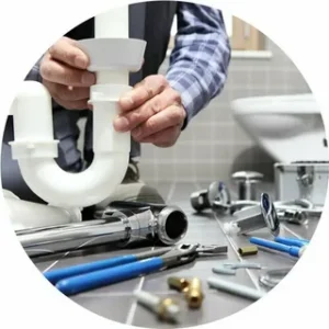 Professional plumber installing a white plastic P-trap under a bathroom sink, representing reliable residential plumbing services.