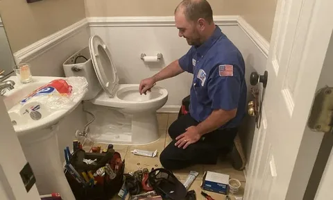 Close-up of a technician utilizing specialized tools for bathroom pipe repair and professional plumbing services.