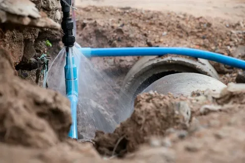 Technicians excavating soil for a main drainage line replacement to solve a local Sewer Repair Problem