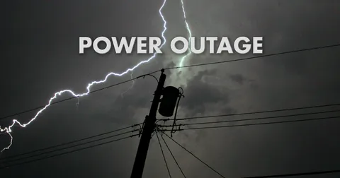 Power grid transformer failure causing sparks and dark city skies to demonstrate common Power Outages Causes