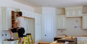 Our Blogs 7 A man is assembling a kitchen cabinet as part of a kitchen remodeling project.