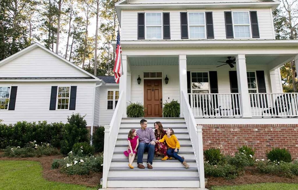 The Ultimate Guide to Mortgage Loans in Virginia: From Pre‑Approval to Closing 2 An American family is sitting outside on the stairs of their newly built home hwich is financed by mortgage services.