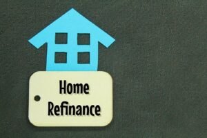 paper houses and wooden tags with the words HOME REFINANCE concept home refinance Virginia