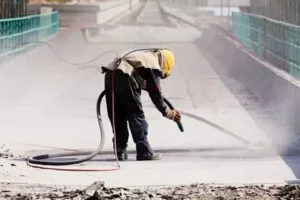 Our Blogs 7 Abrasive sandblasting service being performed on machinery for surface preparation