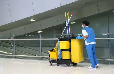 Professional daytime porter services cleaning and mopping a commercial office building hallway