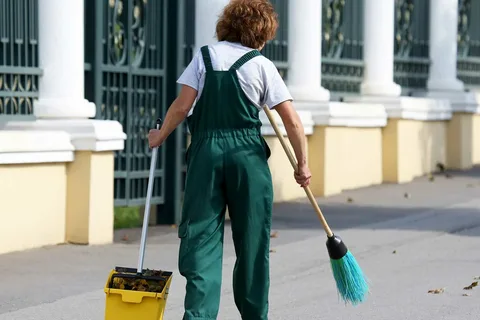 What Are Porter Services and Why Do You Need Them? 1 Janitorial staff cleaning a high-traffic entryway with a mop and bucket as part of daily commercial porter services.