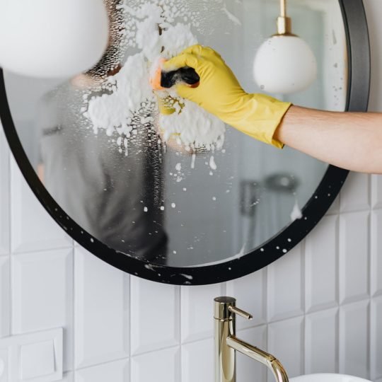 canva-faceless-person-cleaning-mirror-in-bathroom-MAD_9u9UzwY